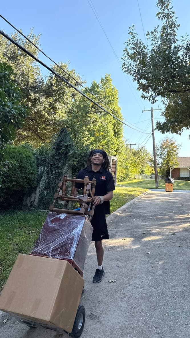 Crew member moving wrapped furniture on a dolly